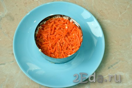 Морковь по-корейски нарежьте немного мельче, чем она есть, и выложите следующим слоем салата, нанесите майонез.