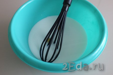 В миске соедините тёплые молоко и воду, добавьте яйца, перемешайте венчиком до однородного состояния.