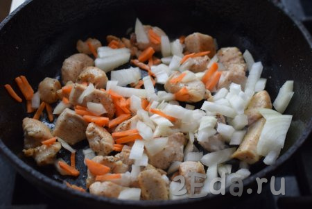Далее в сковороду к филе кладём лук и морковь, перемешиваем всё и жарим на медленном огне до прозрачности овощей (примерно, 5 минут).