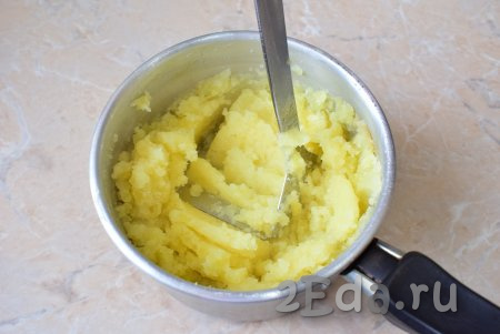 Горячую воду слейте, а картофель разомните в пюре (удобно разминать картошку с помощью толкушки), дайте совсем немного остыть.
