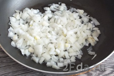Очищенную луковицу нарежьте достаточно мелко, выложите на сковороду, хорошо разогретую с растительным маслом. Обжарьте лук на среднем огне до мягкости (на это потребуется минут 5), не забывая помешивать.