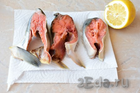 Подготовьте рыбу. Если используете целую горбушу, то предварительно её разморозьте, удалите внутренности и тщательно промойте. Затем нарежьте рыбу на порционные кусочки. Подготовленные кусочки горбуши выложите на бумажные полотенца, чтобы удалить лишнюю влагу. Затем сбрызнете рыбку небольшим количеством лимонного сока, который уберёт навязчивый рыбный запах.