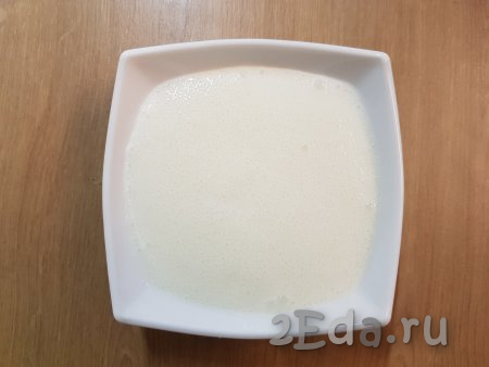 В отдельную тарелку налить кефир, добавить к нему соду и хорошо перемешать (на поверхности кефира должны появиться пузырьки).