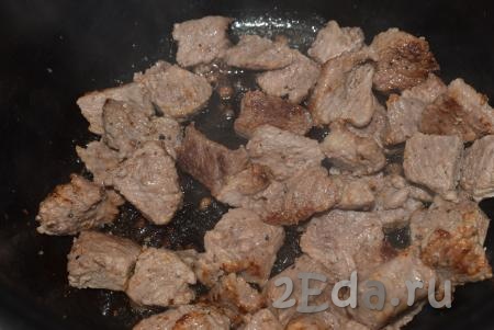 Когда вся жидкость из говядины выпарится и она начнет подрумяниваться, добавляем к мясу нарезанный лук.