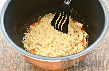 Пропаренный рис тщательно промыть, откинуть на сито, дать воде полностью стечь. Выложить рис ровным слоем поверх кусочков филе и овощей.