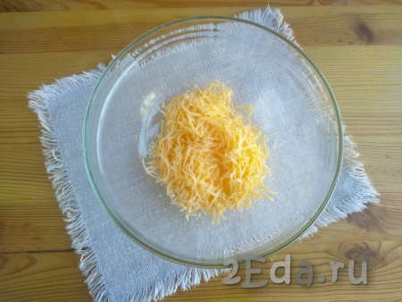 Выложить в миску сыр, натёртый на мелкой тёрке.