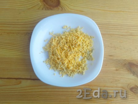 Оставшуюся половину яичного желтка натереть на мелкой тёрке.