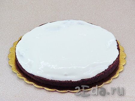 Теперь можно приступить к сборке черёмухового торта. На плоскую тарелку выложить нижний пласт коржа, обильно смазать сметанным кремом.