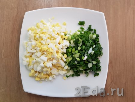 2 яйца необходимо предварительно сварить вкрутую (варить минут 10 с момента закипания воды), затем дать им остыть, очистить. Нарезать варёные яйца на небольшие кубики. Зелёный лук вымыть и нарезать мелко.