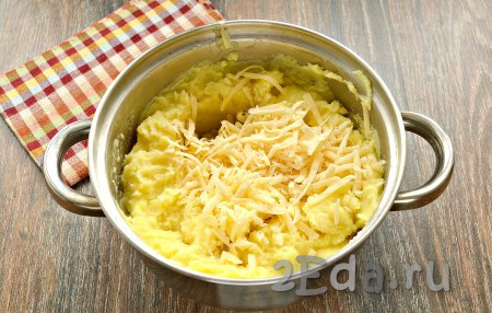 В горячее картофельное пюре выложить натёртый на крупной тёрке сыр, очень хорошо перемешать ложкой.