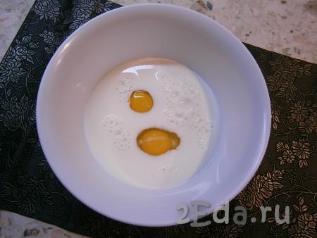 В молоко комнатной температуры всыпать сахар и добавить сырые яйца.