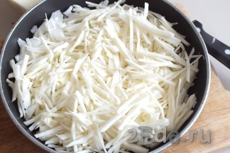 Пока дрожжи активируются, приготовим начинку, для этого капусту нарежьте тонкой соломкой. Очищенную луковицу нарежьте произвольно. В сковороду налейте 3 столовые ложки растительного масла, разогрейте, выложите нарезанные лук и капусту.
