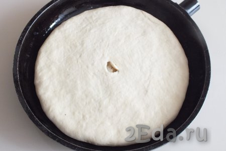 Слегка натягивая краешки верхнего пласта теста, подверните их под нижний пласт. В центре пирога сделайте отверстие для выхода пара. Прикройте полотенцем подготовленный пирог и оставьте на 15 минут на расстойку.