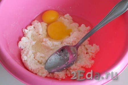 Добавьте к творожной массе 2 яйца, перемешайте ложкой до однородности.
