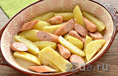 Выложить картошку с сосисками в форму для запекания.