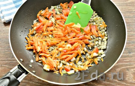 В сковороде разогреть растительное масло, выложить лук, помидор и морковь, обжарить на среднем огне 5 минут, иногда перемешивая.