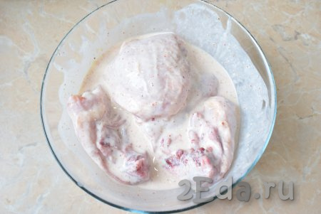 В таком маринаде можно готовить любые части курицы. Я буду готовить куриные бёдра, их нужно предварительно вымыть и немного обсушить, а затем выложить в миску с маринадом. Бёдрышки тщательно обмазать со всех сторон маринадом из кефира, чеснока и специй, оставить мариноваться при комнатной температуре на 2-4 часа (можно мариновать и дольше, но тогда уберите чашу с курицей в холодильник).
