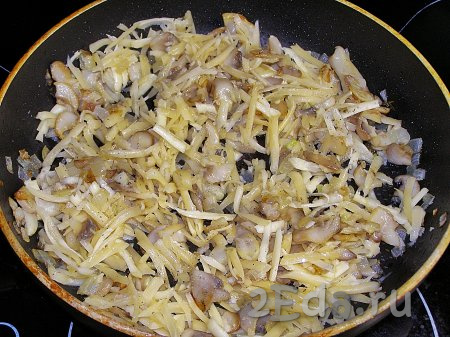 В тёплые грибы кладём натёртый сыр и перемешиваем. По вкусу начинку можно немного посолить и поперчить.