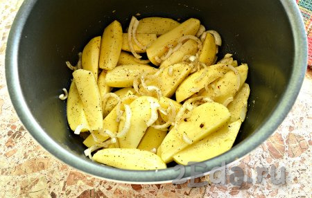 Дно съёмной чаши мультиварки смазать растительным маслом, выложить ломтики картошки с луком.