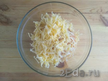 Сыр натереть на средней тёрке. Половину натёртого сыра выложить в миску к фаршу.