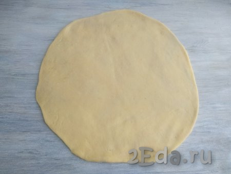 На присыпанной мукой поверхности раскатать охладившееся тесто в круглый пласт толщиной 2-3 мм.