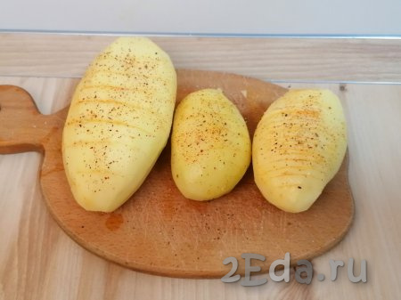 Таким образом подготовьте все картофелины. Смажьте картошку-гармошку со всех сторон растопленным сливочным (или растительным) маслом. Подсолите каждую картофелину и поперчите. По желанию, можно добавить паприку или любую другую приправу.