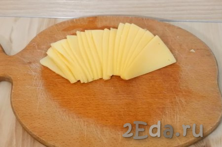 Сыр нарежьте на маленькие, тонкие ломтики. 