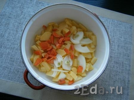 Картошку, морковь и лук очистить. Картофель, половину луковицы и морковь нарезать небольшими кусочками в кастрюлю.
