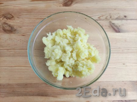 Тщательно слить воду из кастрюли, растолочь картофель с помощью толкушки.