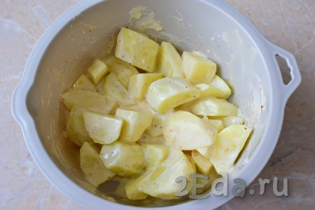 Нарезанный картофель выложите в смесь майонеза, яйца и чеснока, хорошо перемешайте, чтобы чесночно-майонезный соус полностью покрыл кусочки картошки со всех сторон.