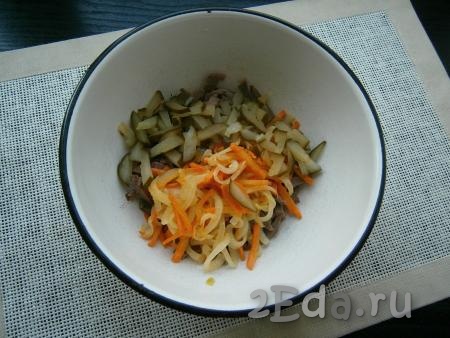 Затем овощи немного остудить. Нарезать соломкой маринованный огурец и добавить к брусочкам свиного сердца, туда же всыпать обжаренные лук с морковью.