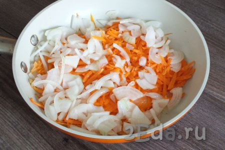Очищенную луковицу нарежьте четверть кольцами, натрите на крупной тёрке очищенную морковку, выложите их на хорошо разогретую с растительным маслом сковороду. Обжарьте овощи, иногда помешивая, на среднем огне до мягкости (на это потребуется около 6-7 минут).