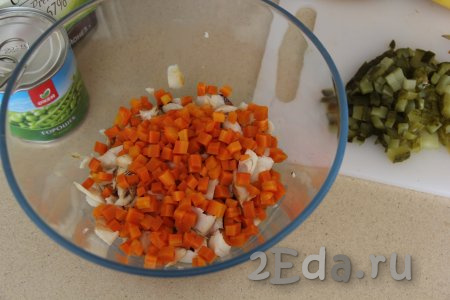 К копчёной треске выложить варёную морковку, нарезанную на кубики.