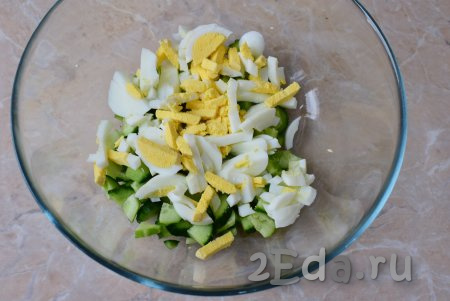 Нарежьте яйца на достаточно тонкие полоски и добавьте к огурцам.