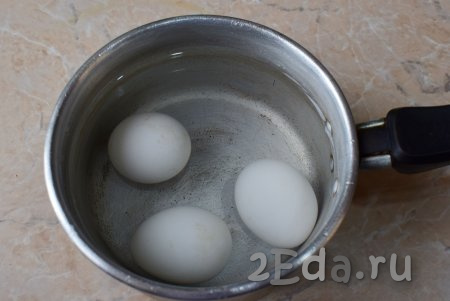 Для приготовления салата отварите яйца заранее в кипящей воде в течение 8-10 минут, затем остудите их, залив холодной водой, а после этого очистите.