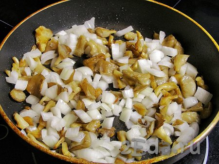Добавляем к грибам нарезанный лук, перемешиваем и обжариваем ещё 3-4 минуты (до мягкости лука), иногда перемешивая.