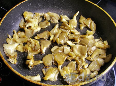 В сковороде разогреваем 50 мл подсолнечного масла и выкладываем вешенки, обжариваем, помешивая, минуты 3, на среднем огне (грибы должны слегка подрумяниться).