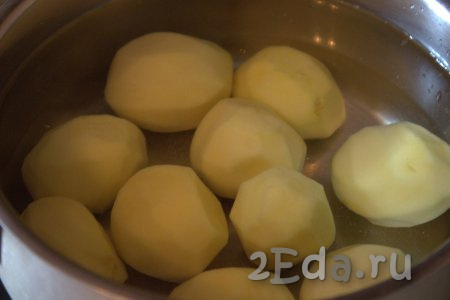 Картофелины среднего размера вымыть, очистить от кожуры. Старайтесь чистить так, чтобы картошка приобрела форму "бочонка". В кастрюлю с очищенной картошкой влить воду, поставить на огонь и слегка посолить. Варить клубни до полуготовности (с момента закипания воды варить минут 7). Продолжительность варки во многом зависит от сорта картофеля. Отваренная картошка должна хорошо держать форму, но не развалиться. 