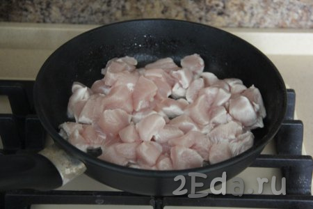 В разогретую сковороду влить растительное масло и выложить кусочки курицы.