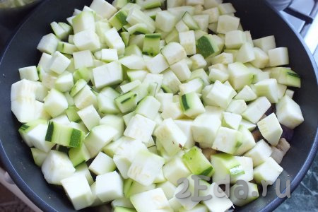 После добавьте нарезанные кабачки, перемешайте и обжаривайте овощи в течение 5-7 минут. 