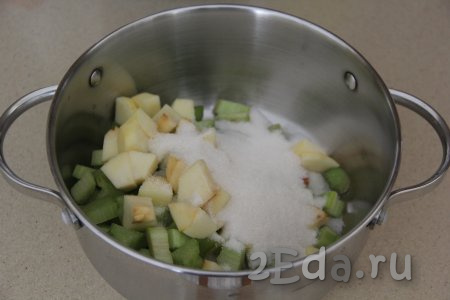 В кастрюлю, в которой будете варить компот, выложить ревень и яблоко, всыпать сахар.