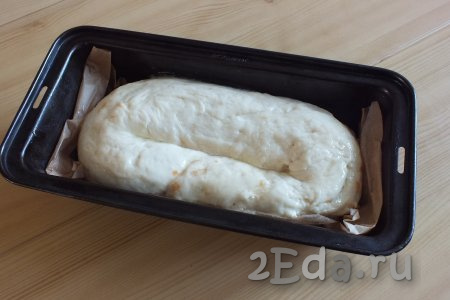 Возьмите прямоугольную форму для кекса (ориентировочно 25 см на 15 см), застелите её пекарской бумагой. Выложите в неё подготовленный рулет в виде вытянутого "бублика" (как на фото). Смажьте пирог яичным белком.