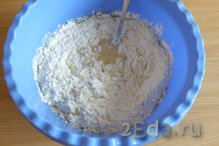 Всыпьте дрожжи с сахаром в молочно-масляную смесь, постепенно добавляя муку, начните замешивать тесто с помощью ложки.