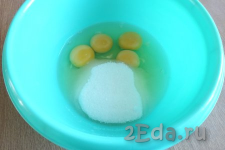 В просторной миске соедините яйца и сахар, взбейте миксером в течение 4-5 минут. Яично-сахарная масса в процессе взбивания должна увеличиться в объёме, стать достаточно светлой и пышной.
