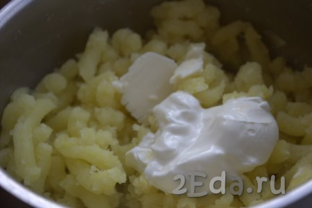 К картофельному пюре добавить сливочное масло и сметану, размять толкушкой до однородности и оставить до полного остывания.