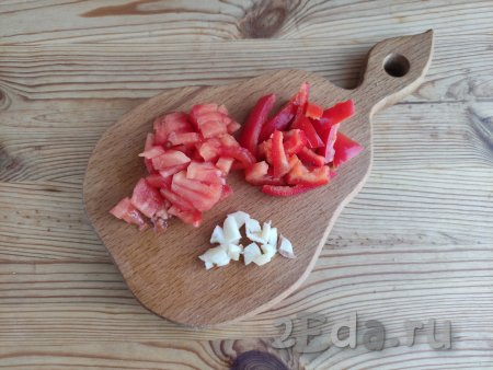 С помидоров снять кожицу, болгарский перец очистить от семян, с чеснока удалить шелуху, промыть овощи. Чеснок нарезать на тонкие пластины, а помидоры и перец - брусочками.