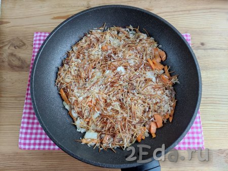 Затем на сковороду к вермишели с рисом добавить обжаренные лук с морковью, перемешать.