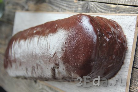 Полить торт "Баунти" тёплой шоколадной глазурью и поставить в холодильник на 20 минут. Глазурь стабилизируется, но будет мягкой и не текучей.