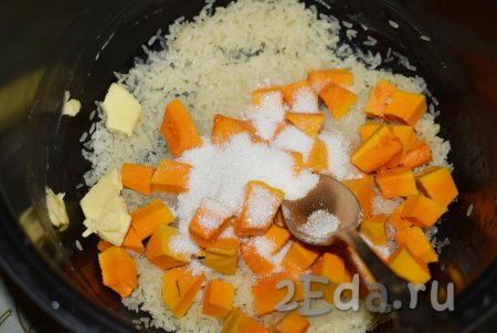 Далее на рис выкладываем нарезанную тыкву. Добавляем сахар, соль и сливочное масло.