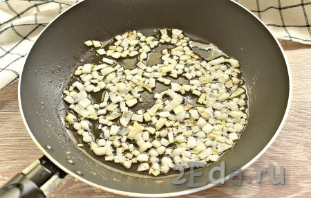 В сковороде прогреваем растительное масло и выкладываем нарезанный лук, обжариваем его на среднем огне до лёгкой золотистости (примерно, 2-3 минуты).